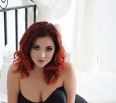 Lucy V teasing on the bed in her black bras and high waist