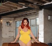 Lucy V teasing in her yellow bodysuit on the gym horse
